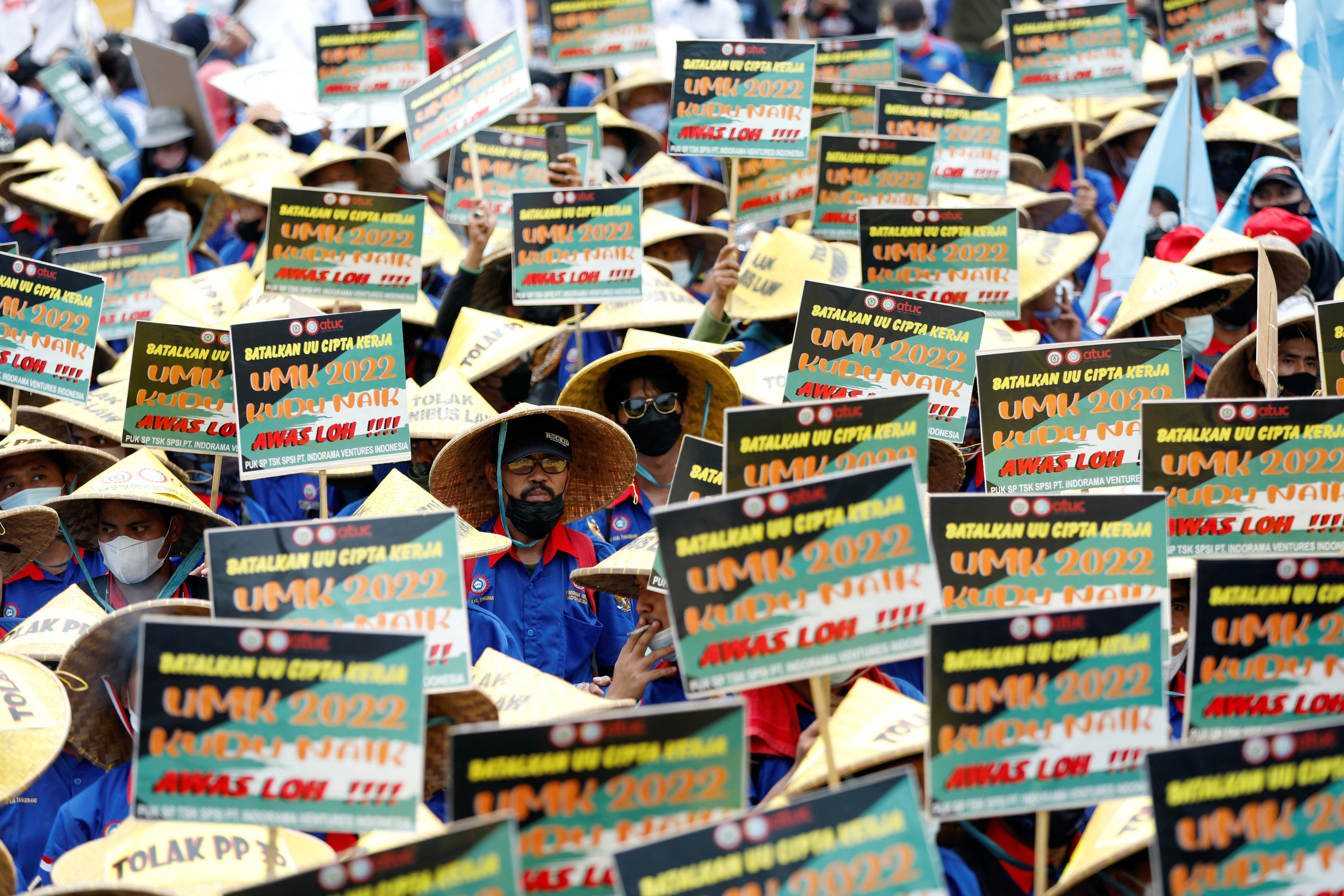 Members of Indonesian trade unions hold placards during a protest against the government's labor reforms, as Indonesia's Constitutional Court reads the verdict on a judicial review filed on the controversial 'omnibus' or job creation law in Jakarta, Indonesia, on November 25, 2021. (Reuters)