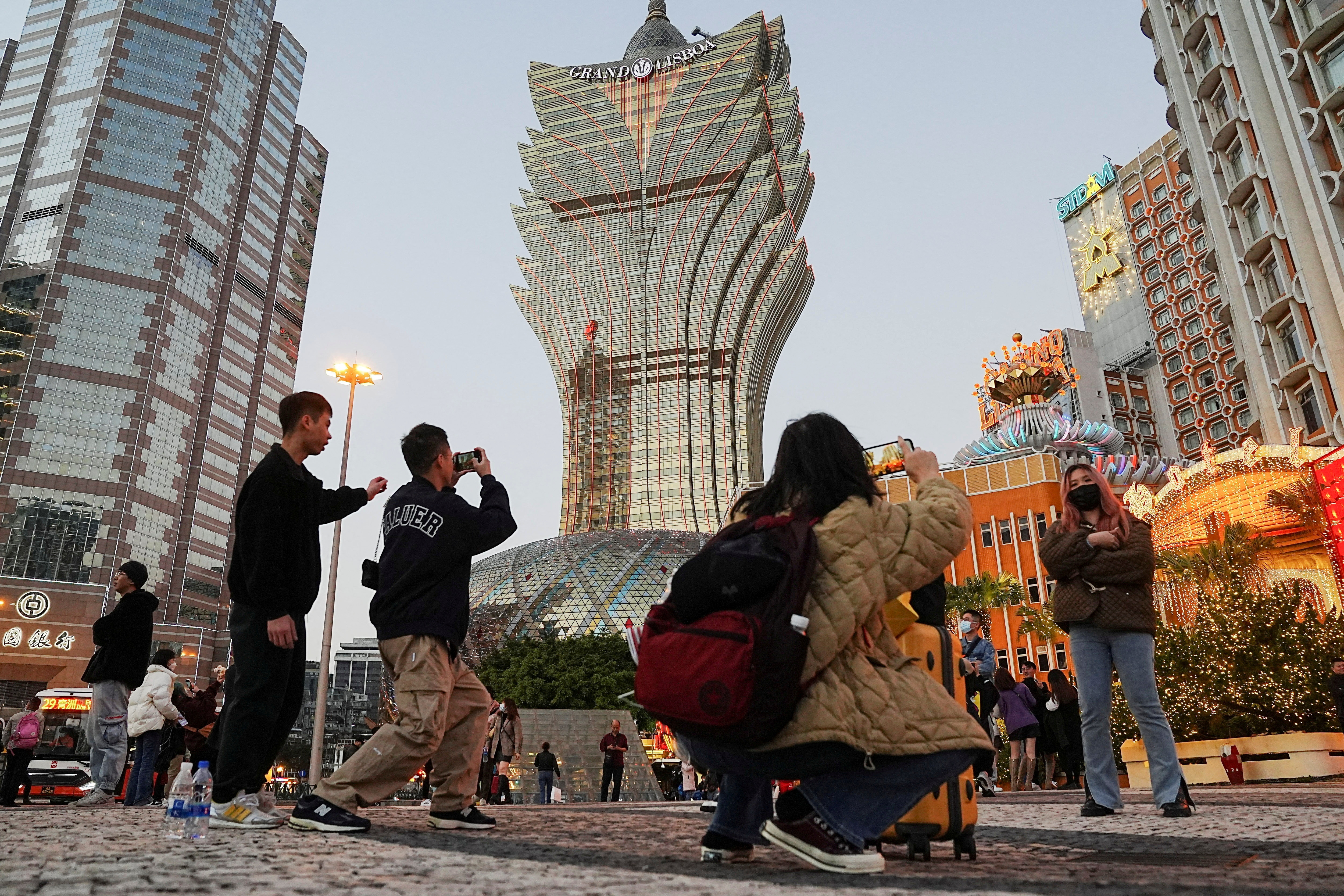 Visitors pose for photos outside the Grand Lisboa casino operated by SJM Holdings during Lunar New Year in Macau, China, on Jan 24, 2023. (Reuters)
