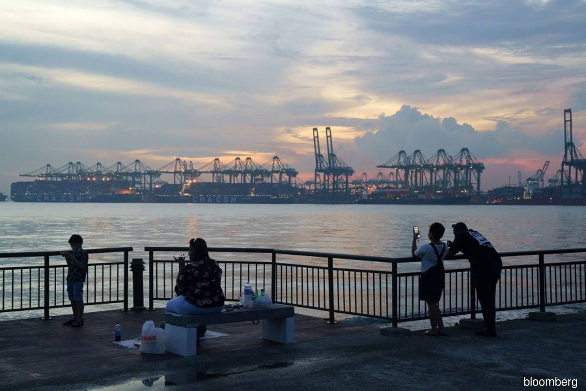 Gantry cranes at the Pasir Panjang terminal in Singapore in the background. (Photo by Ore Huiying/Bloomberg)