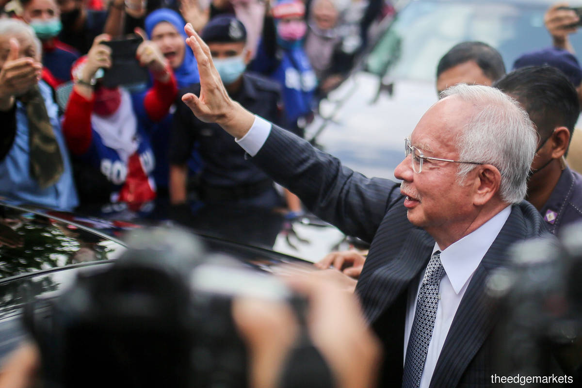 Najib waving at supporters outside the Palace of Justice in Putrajaya on Tuesday (Aug 23). (Photo by Mohamad Shahril Basri/The Edge)