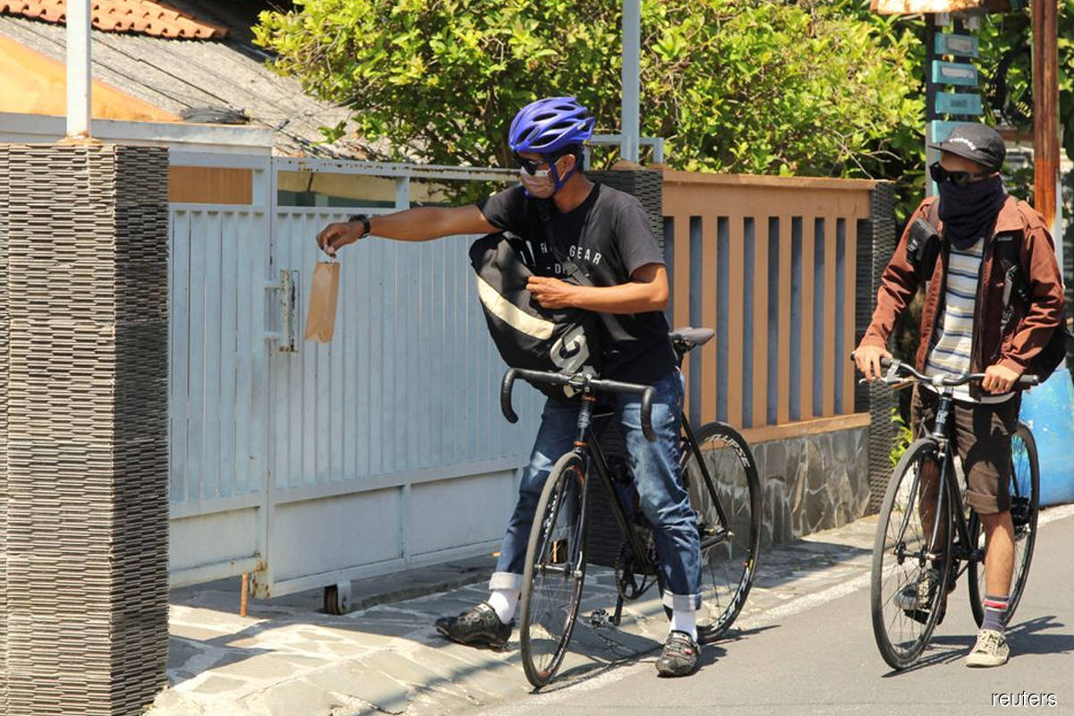 Bicycle riding volunteers deliver medicines in Indonesia's Semarang
