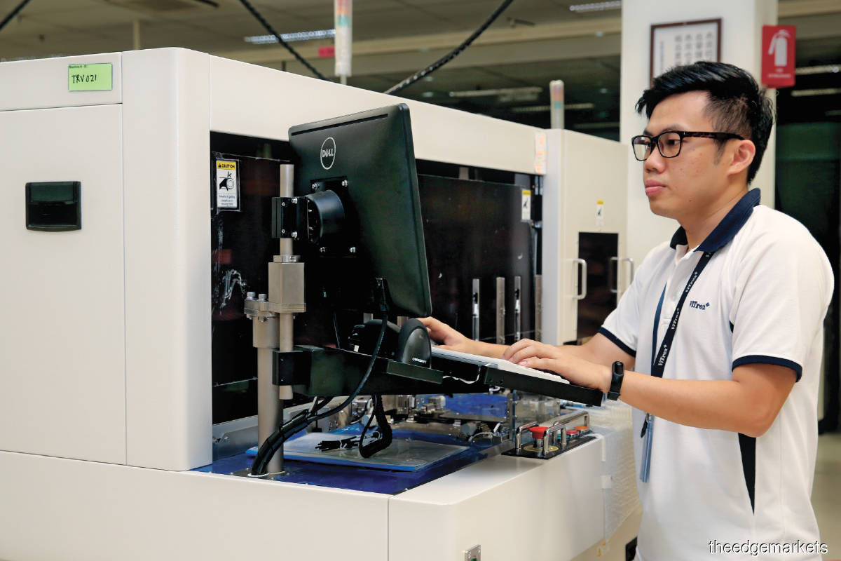 A ViTrox manufacturing engineer operating a semiconductor component inspection handler. (Photo by Sam Fong/The Edge)