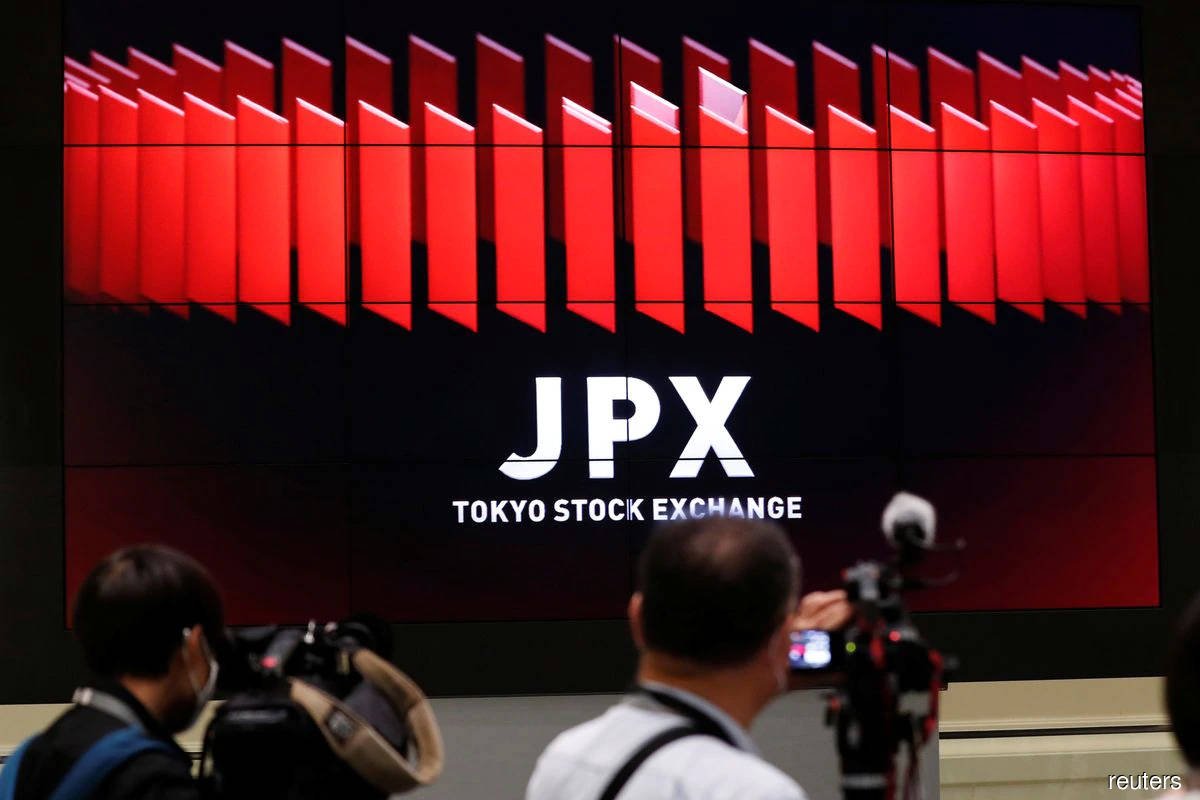 Japanese shares hover near session high on hints of Fed rate pause