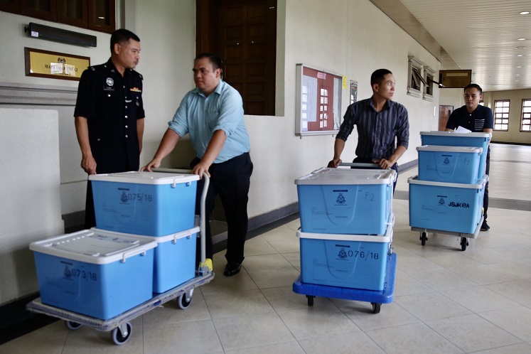 Plastic boxes of pictures of the jewellery, handbags and other valuable items to be shown to the applicants were brought to the courtroom. (Photo by Sam Fong/The Edge)