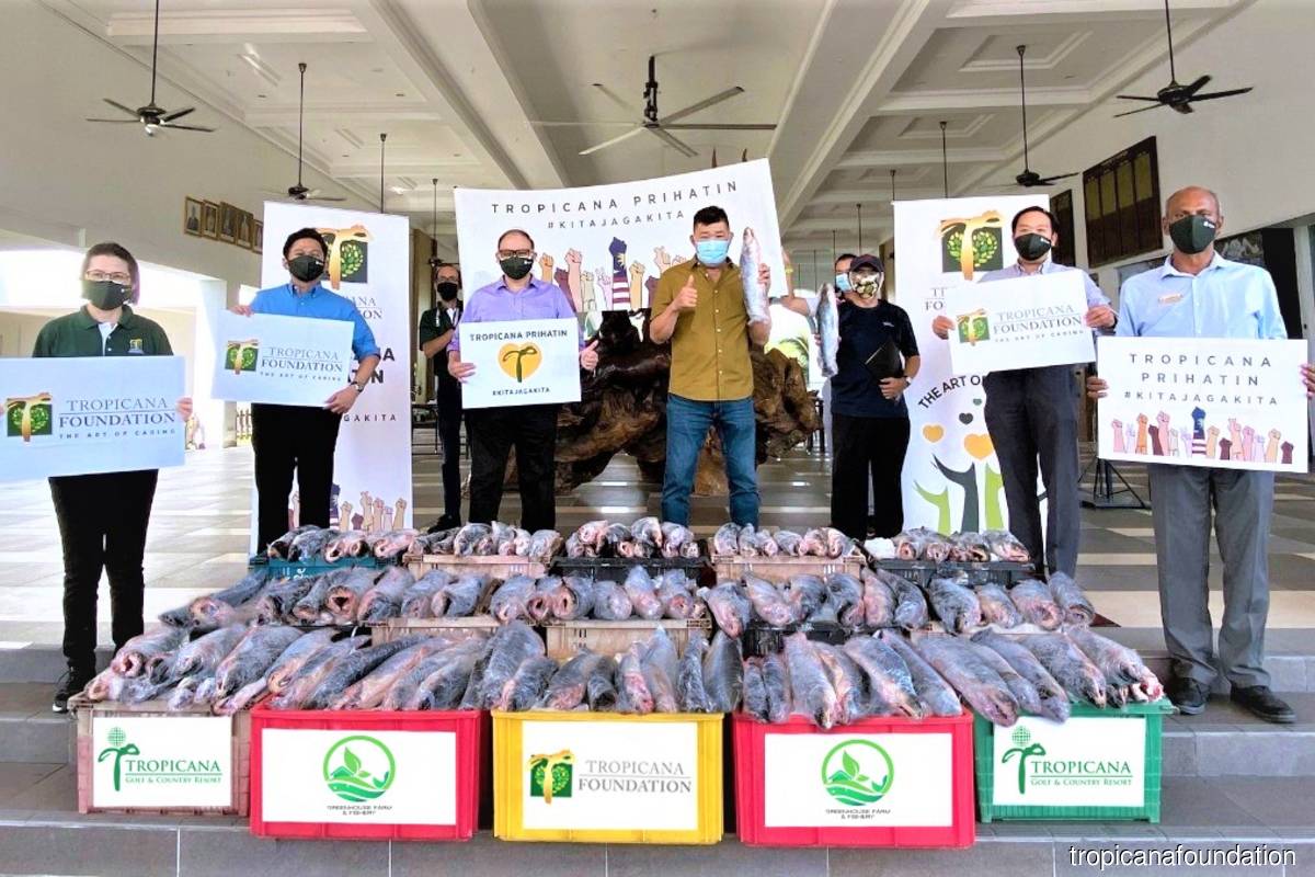 Tropicana donated over 1,000 kg of silver catfish to 628 underprivileged households in the Klang Valley. Foo (third from left) and Kuan (fourth from left) commemorate the delivery.