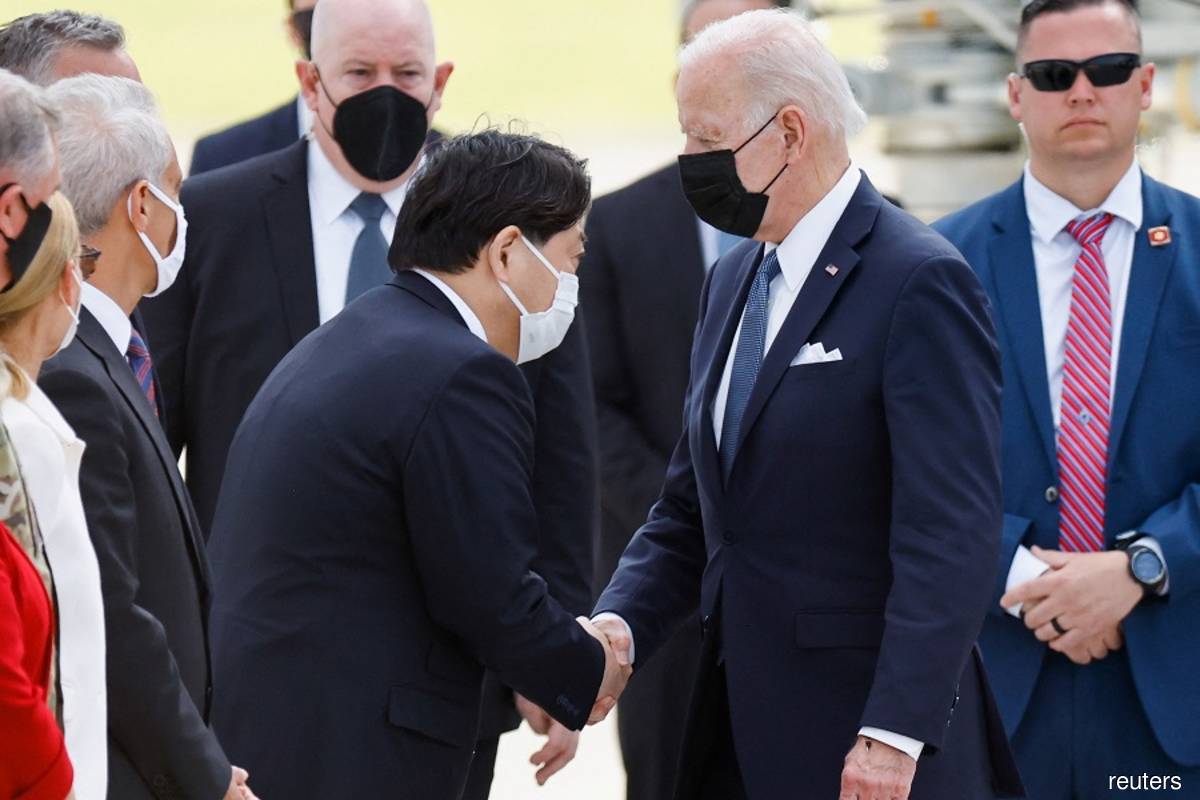 US President Joe Biden shakes hands with Japanese Foreign Minister Yoshimasa Hayashi upon his arrival at Yokota U.S. Air Force Base in Fussa, on the outskirts of Tokyo, Japan on Sunday, May 22, 2022. (Photo by Kim Kyung-Hoon/Reuters)