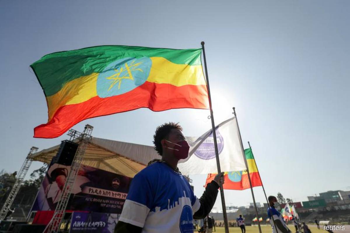 A volunteer holds an Ethiopian flag during a blood donation ceremony for the injured members of Ethiopia's National Defense Forces (ENDF) fighting against Tigray's special forces on the border between Amhara and Tigray, at the stadium in Addis Ababa, Ethiopia on Nov 12, 2020. (Photo by Tiksa Negeri/Reuters filepix)