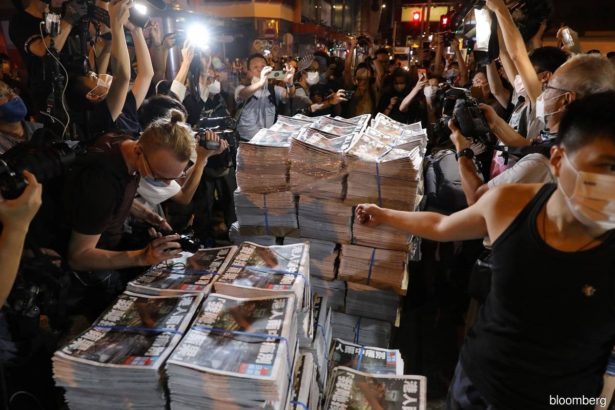 Workers arranging bundles of the final edition of the Apple Daily newspaper at a news stand in Mong Kok, Hong Kong, China on June 24, 2021.