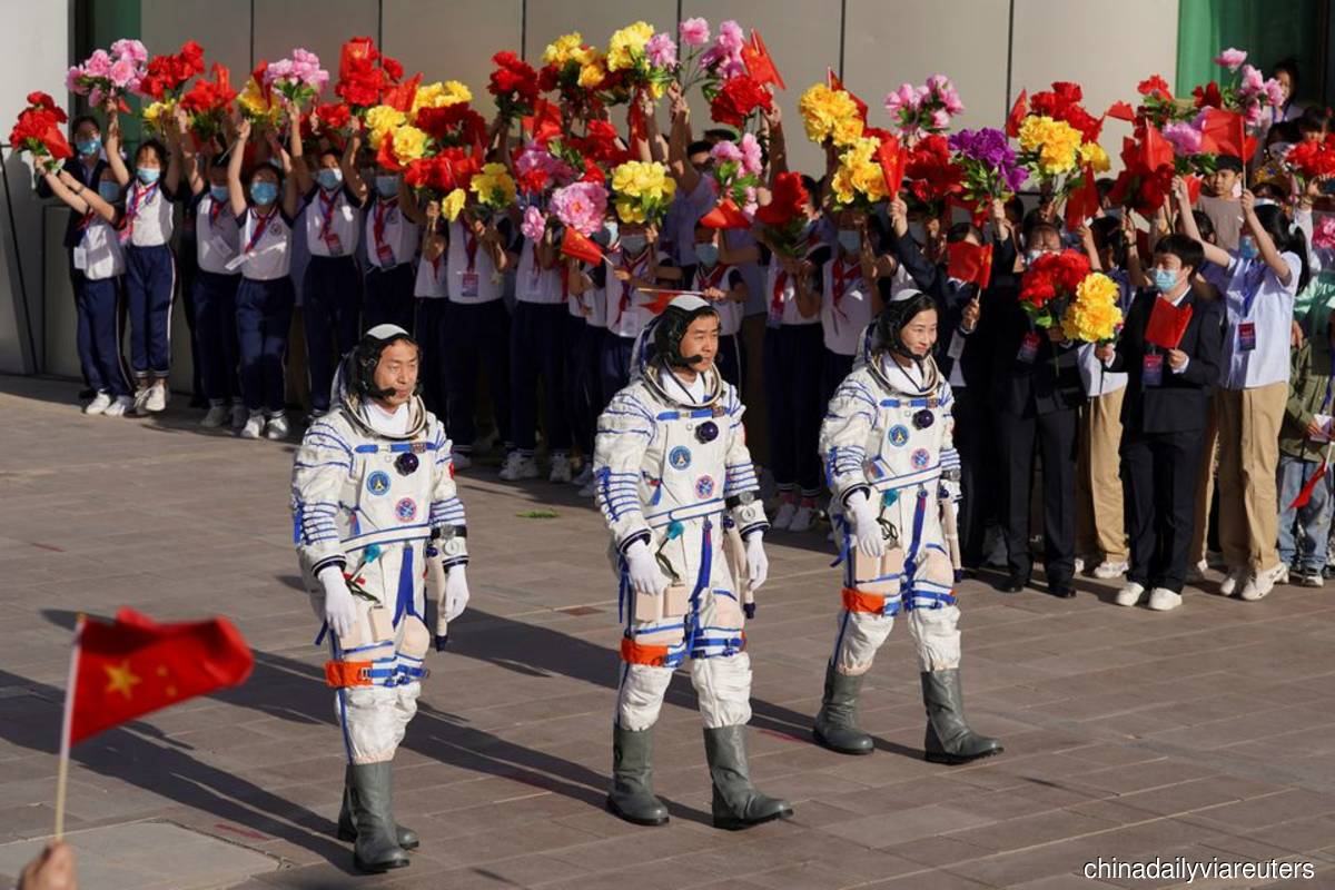 Chinese astronauts Chen Dong, Liu Yang and Cai Xuzhe attend a see-off ceremony before the launch of the Long March-2F carrier rocket, carrying the Shenzhou-14 spacecraft for a crewed mission to build China's space station, at Jiuquan Satellite Launch Center near Jiuquan, Gansu province, China on June 5, 2022. (Photo by China Daily via Reuters)