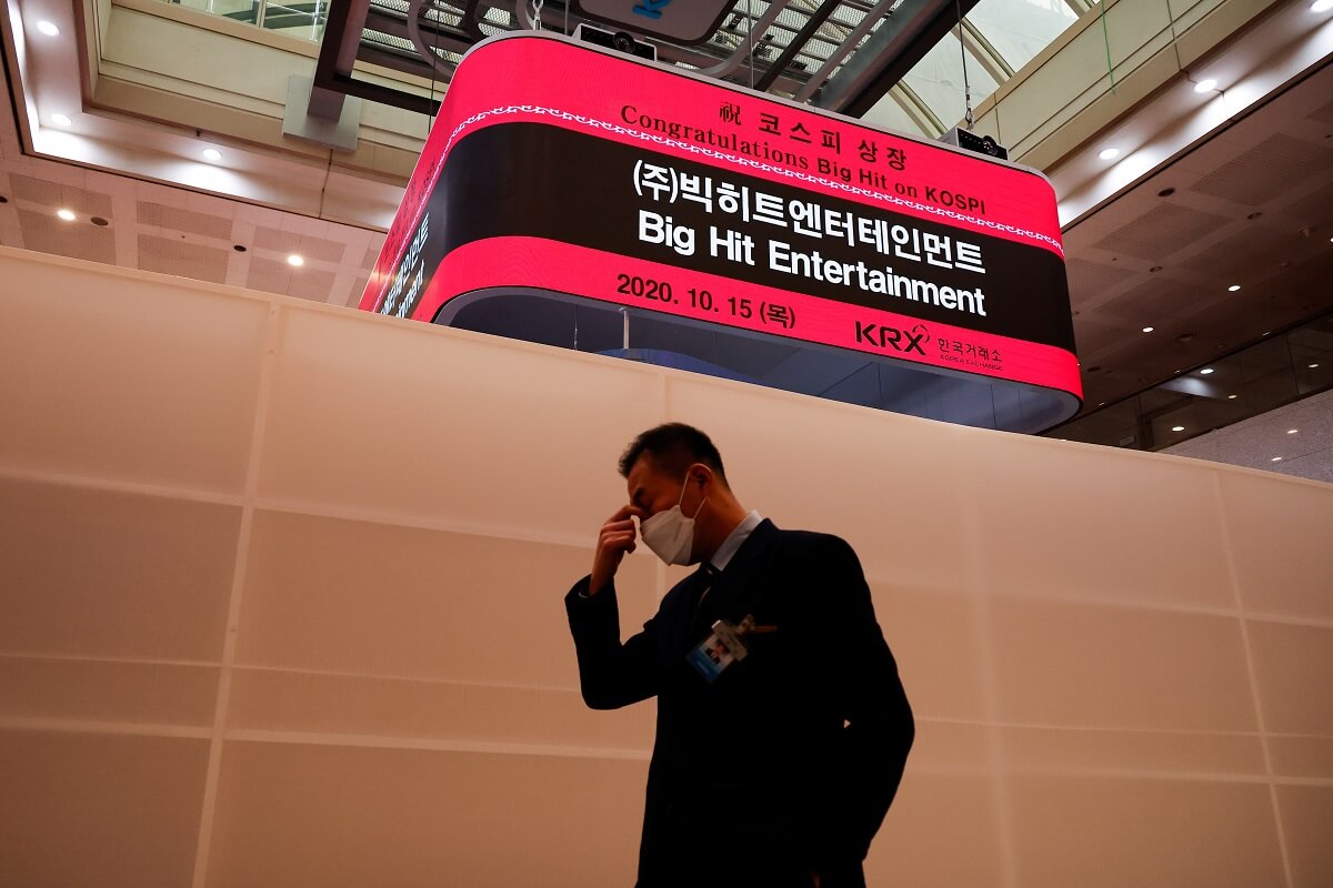 n employee walks past a electronic board showing an information of Big Hit Entertainment's initial public offering ceremony at the Korea Exchange in Seoul, South Korea, Oct 15, 2020. (Photo by Reuters)