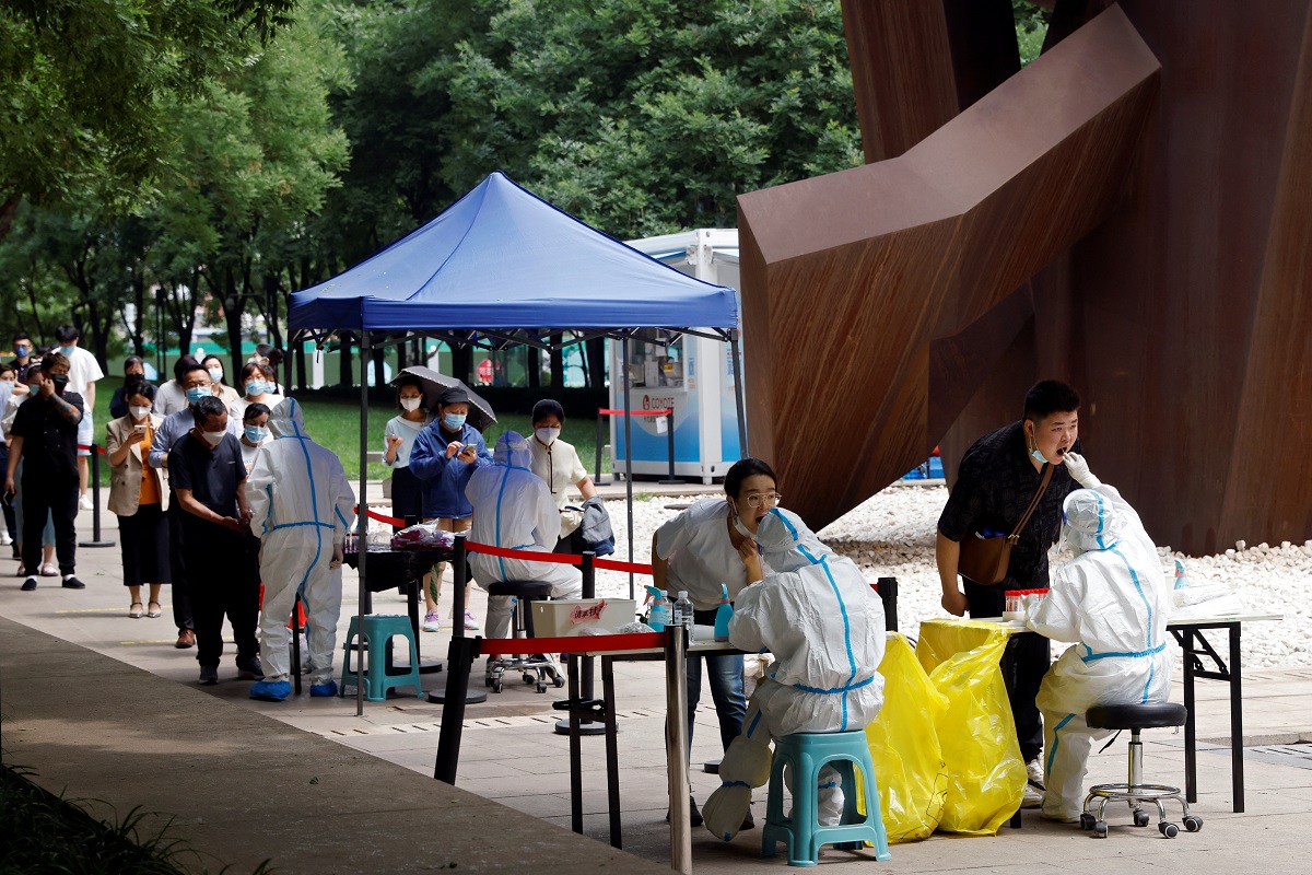 Medical workers in protective suits collect swabs from residents at a makeshift nucleic acid testing site, during a mass testing for Covid-19 in Chaoyang district of Beijing, China June 13, 2022. (Photo by Reuters)