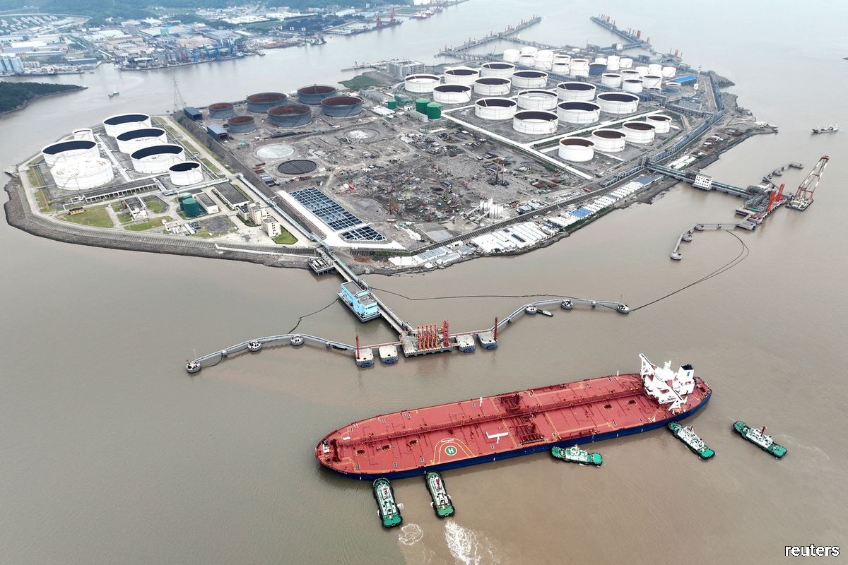 An aerial view showing tugboats helping a crude oil tanker to berth at an oil terminal, off Waidiao Island in Zhoushan, Zhejiang province, China on July 18, 2022. (cnsphoto via Reuters)