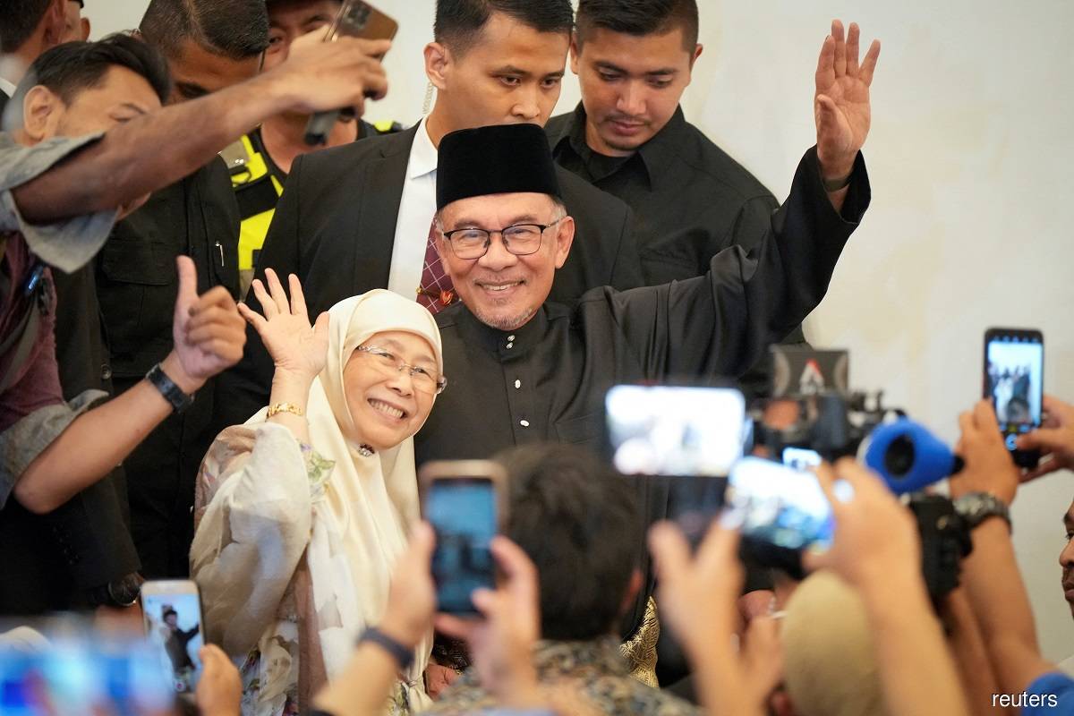 Prime Minister Datuk Seri Anwar Ibrahim and his wife Datuk Seri Dr Wan Azizah Wan Ismail being greeted by loud cheers while arriving at his first press conference held after being sworn in as Malaysia's 10th prime minister on Nov 24, 2022.