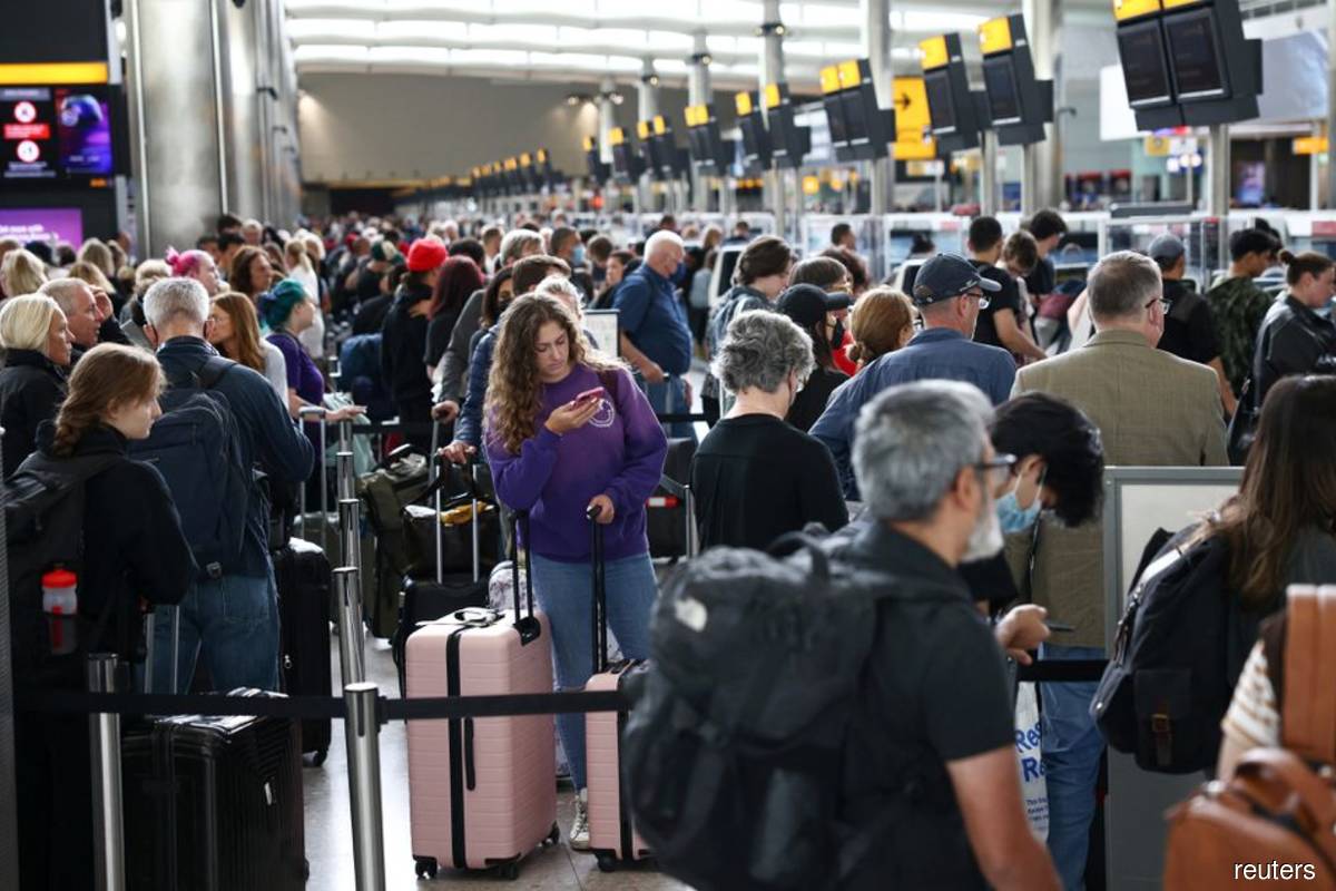 Passengers queue inside the departures terminal of Terminal 2 at Heathrow Airport in London, Britain, June 27, 2022.