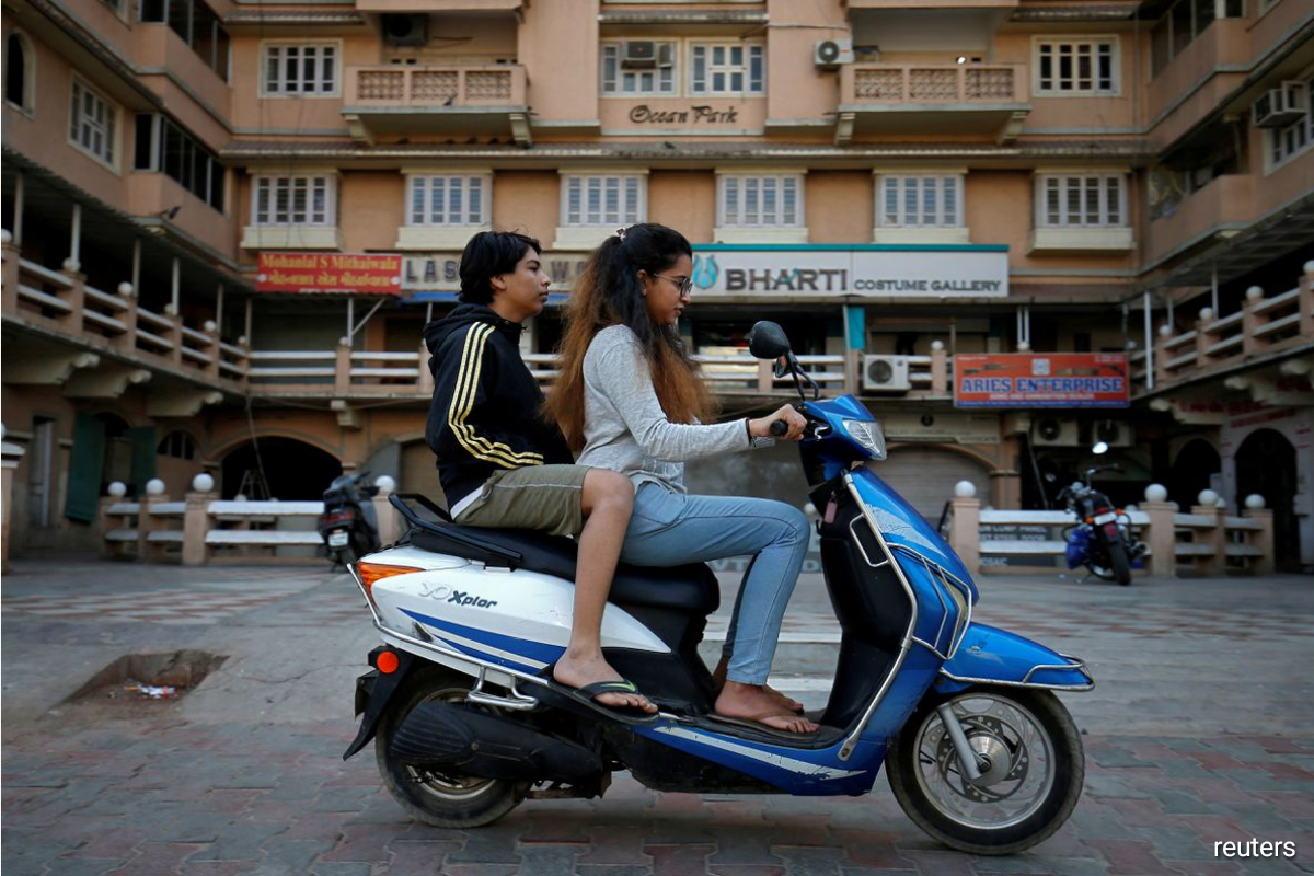 Girls ride an electric scooter in Ahmedabad, India, December 30, 2018. Picture taken December 30, 2018.