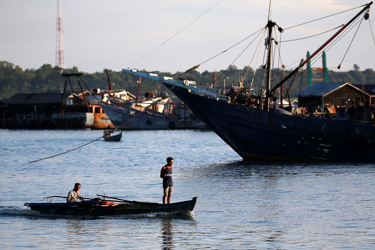 A man stands as he travels on a wooden boat near a port in Tanjungpinang, on the island of Bintan, Indonesia, June 15, 2019. (File photo by Reuters)