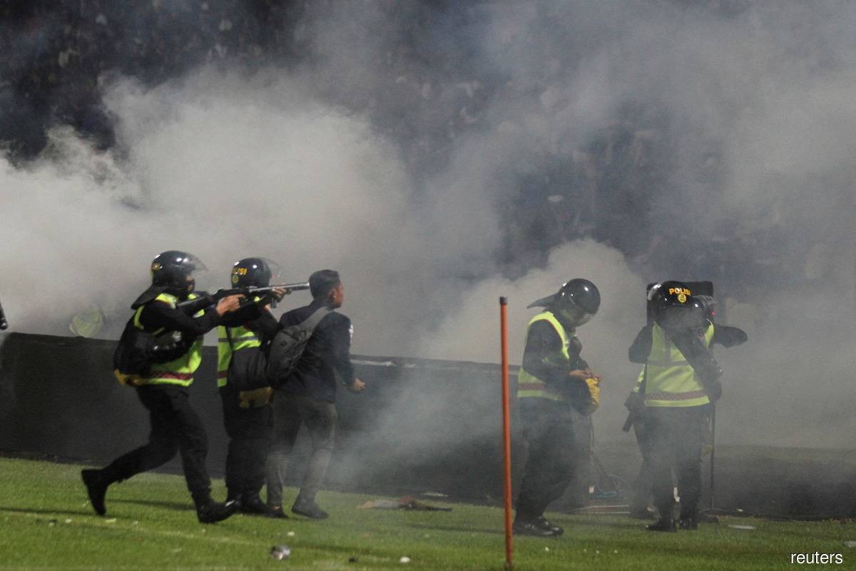 Police officers firing tear gas during a riot after the BRI Liga 1 football match between Arema and Persebaya at the Kanjuruhan Stadium in Malang, East Java province, Indonesia on Oct 1, 2022. Photo by Antara Foto/Ari Bowo Sucipto/Reuters