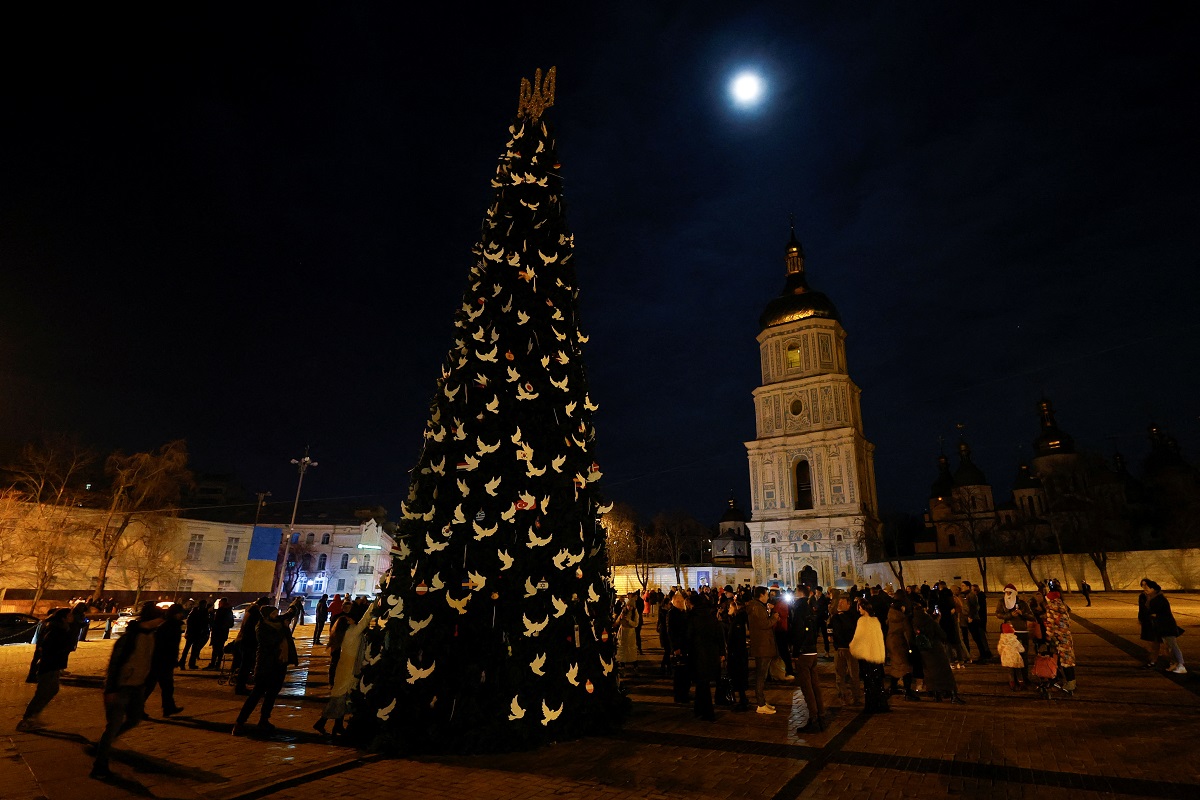 People gathered next to a Christmas tree to celebrate the New Year eve before a curfew, amid Russia's attack on Ukraine, in front of the St Sophia Cathedral in Kyiv, Ukraine on Dec 31, 2022.