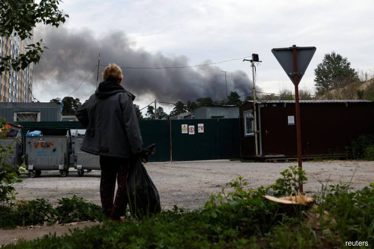 A man looks at the smoke after explosions were heard as Russia's attacks on Ukraine continues, in Kyiv, Ukraine on Sunday, June 5, 2022. (Reuters pix by Edgar Su)