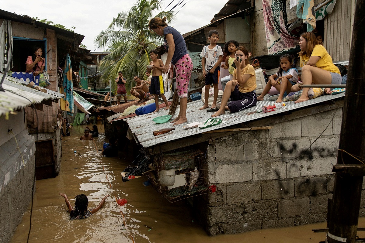 Residents wait on the roof of their homes for the flooding to subside after Super Typhoon Noru, in San Miguel, Bulacan province, Philippines, Sept 26, 2022. (Photo by Reuters)