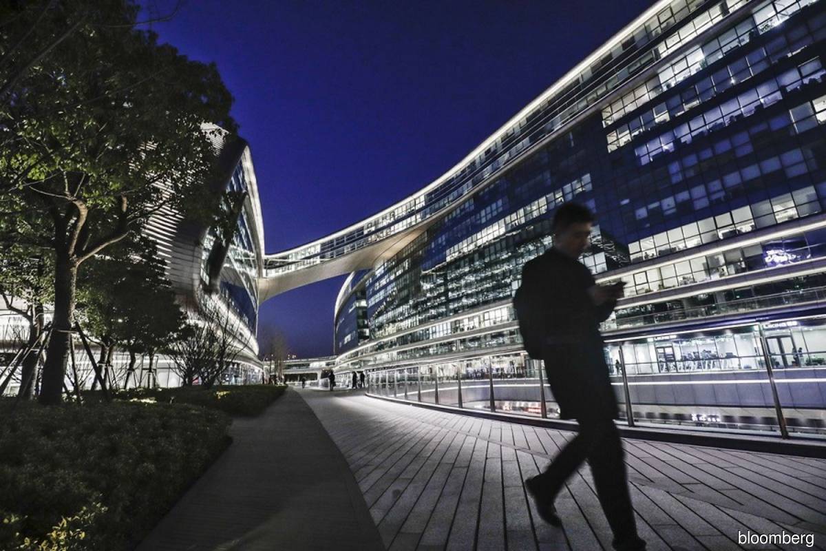 A pedestrian walks past the illuminated Sky Soho building in Shanghai, China. (Photo credit: Qilai Shen/Bloomberg)