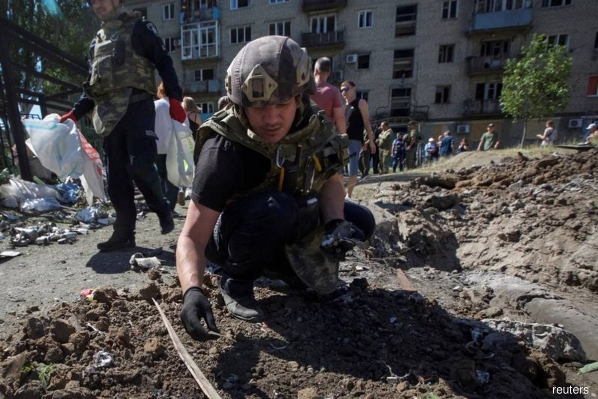 A police expert works near an apartment building destroyed in a military strike, amid Russia's invasion of Ukraine, in Kurakhove, Ukraine on June 7, 2022. (Reuters filepix by Anna Kudriavtseva)