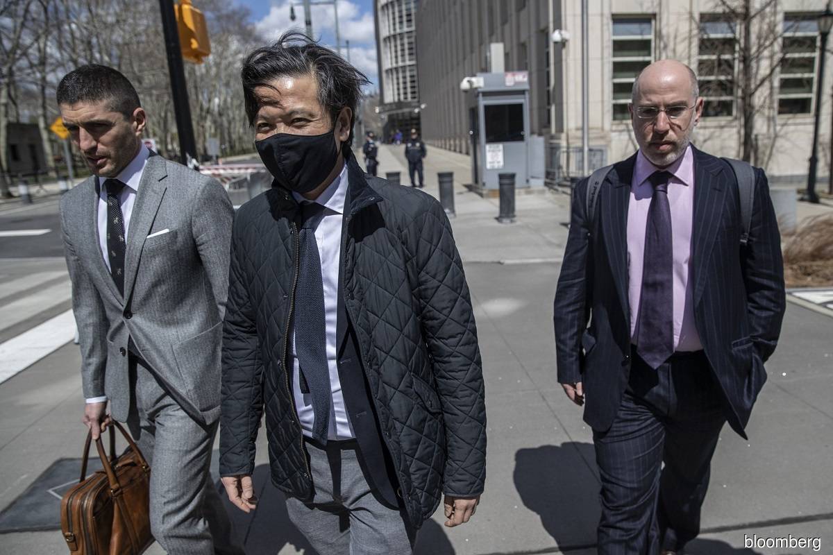 Roger Ng (centre) departs from federal court in the Brooklyn borough of New York.