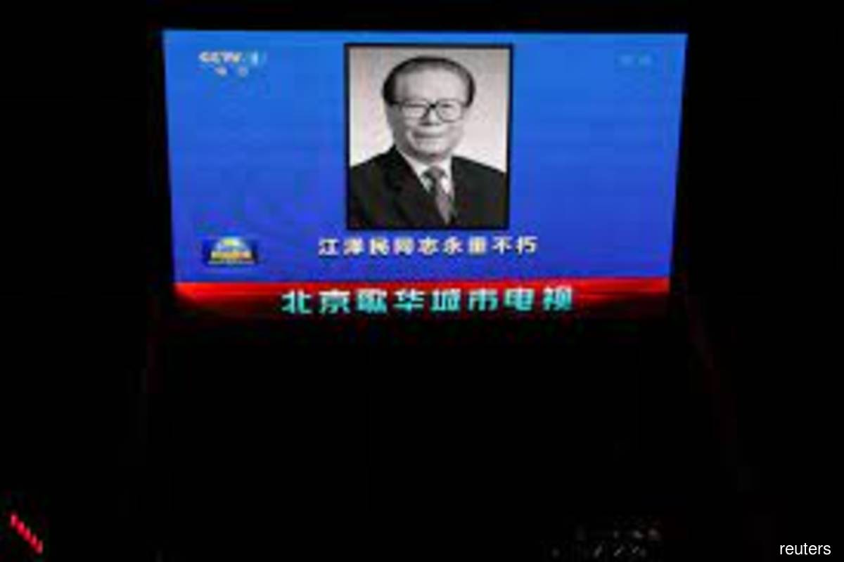 A screen broadcasts news footage of former Chinese President Jiang Zemin following his death in Beijing, China on Nov 30, 2022. (Reuters filepix by Tingshu Wang)