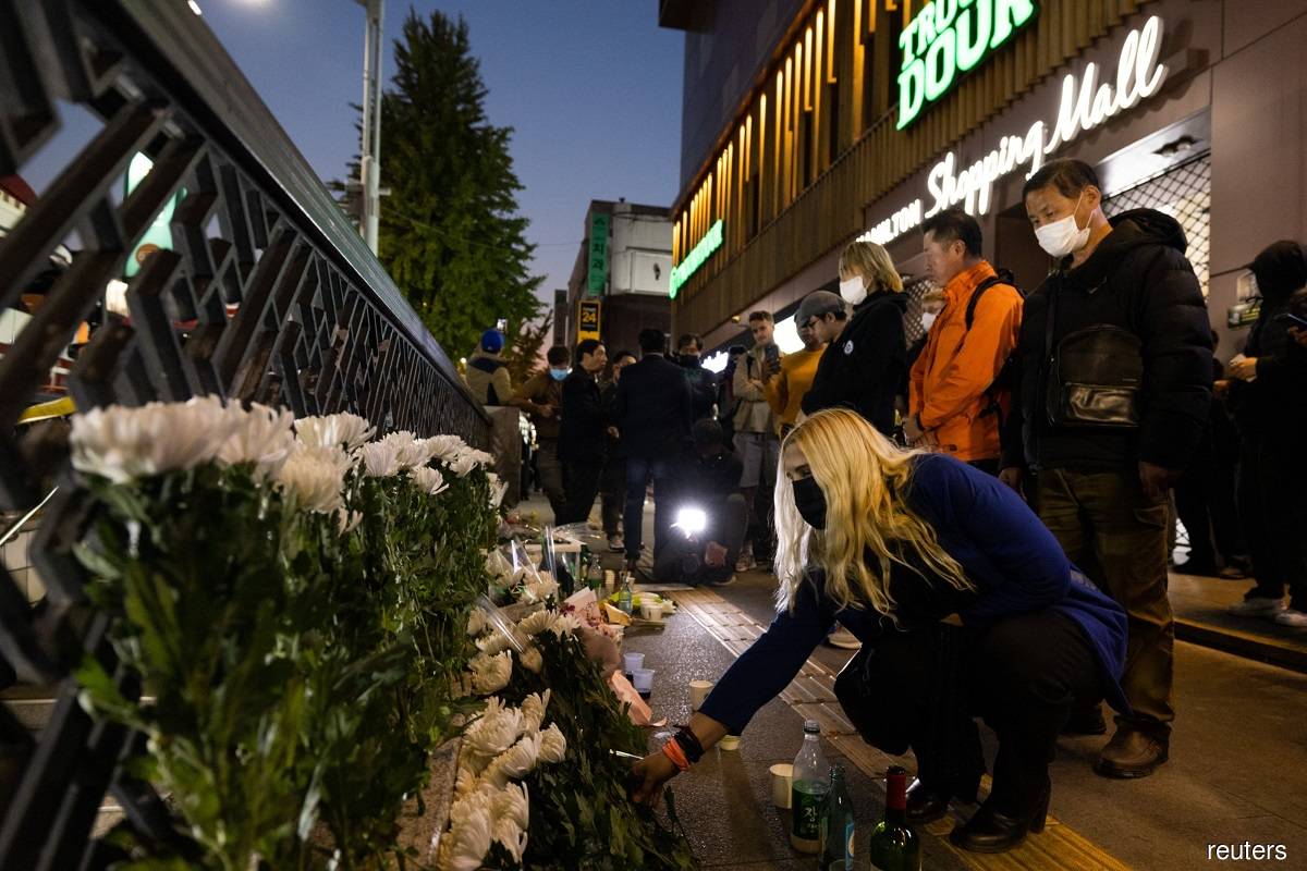 Mourners praying and leaving flowers near the site of a deadly stampede in the Itaewon district of Seoul, South Korea on Oct 30, 2022.