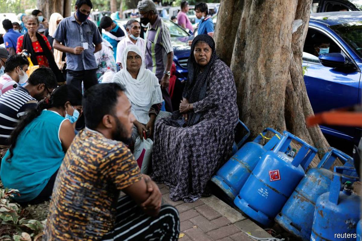 People wait in a line to buy domestic gas tanks near a distributor, amid the country's economic crisis, in Colombo, Sri Lanka, May 23, 2022.