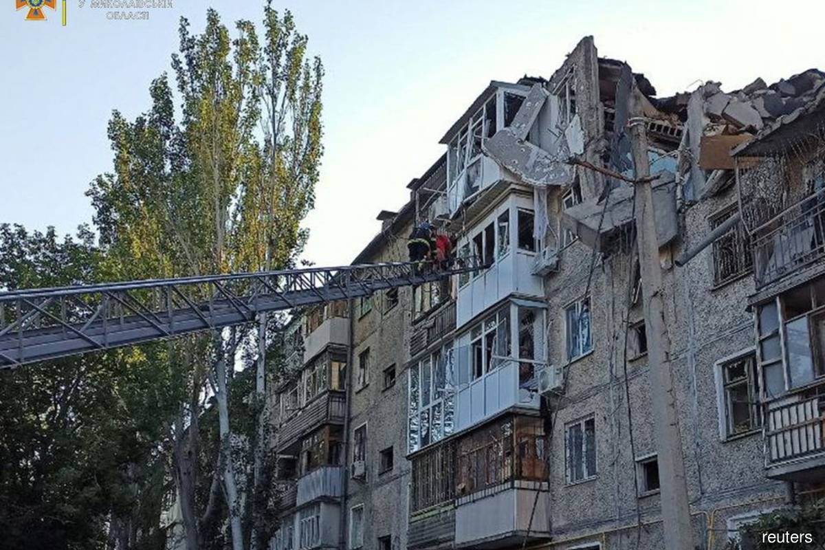 A rescuer helps a man to be evacuated from a residential building hit by a Russian military strike, as Russia's attack on Ukraine continues, in Mykolaiv, Ukraine June 29, 2022. Press service of the State Emergency Service of Ukraine/Handout via Reuters