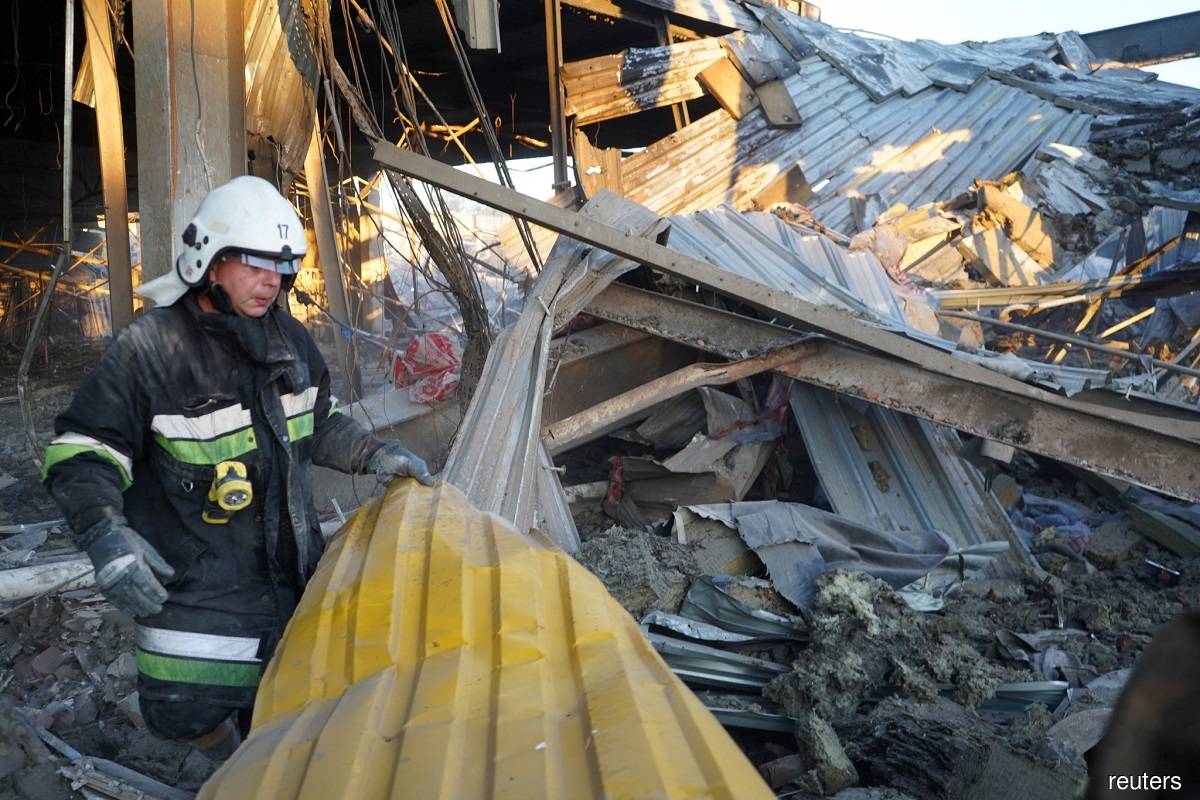A rescuer works at a site of a shopping mall hit by a Russian missile strike, as Russia's attack on Ukraine continues, in Kremenchuk, in Poltava region, Ukraine, in this handout picture released June 28, 2022. Press service of the State Emergency Service of Ukraine/Handout via Reuters