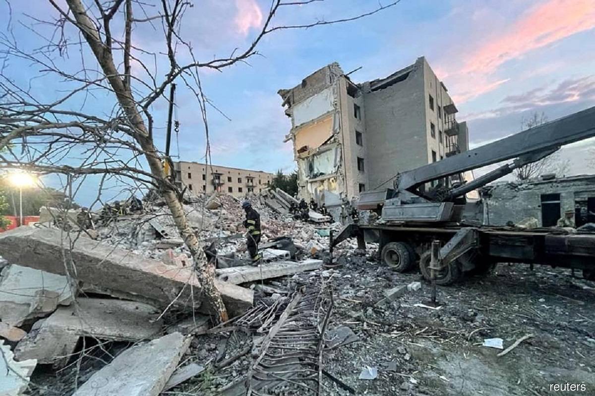 Personnel seen carrying out rescue efforts at the site named as Chasiv Yar on July 10, 2022 after it was hit by a missile strike amid Russia's invasion of Ukraine. Photo by Pavlo Kyrylenko/Reuters
